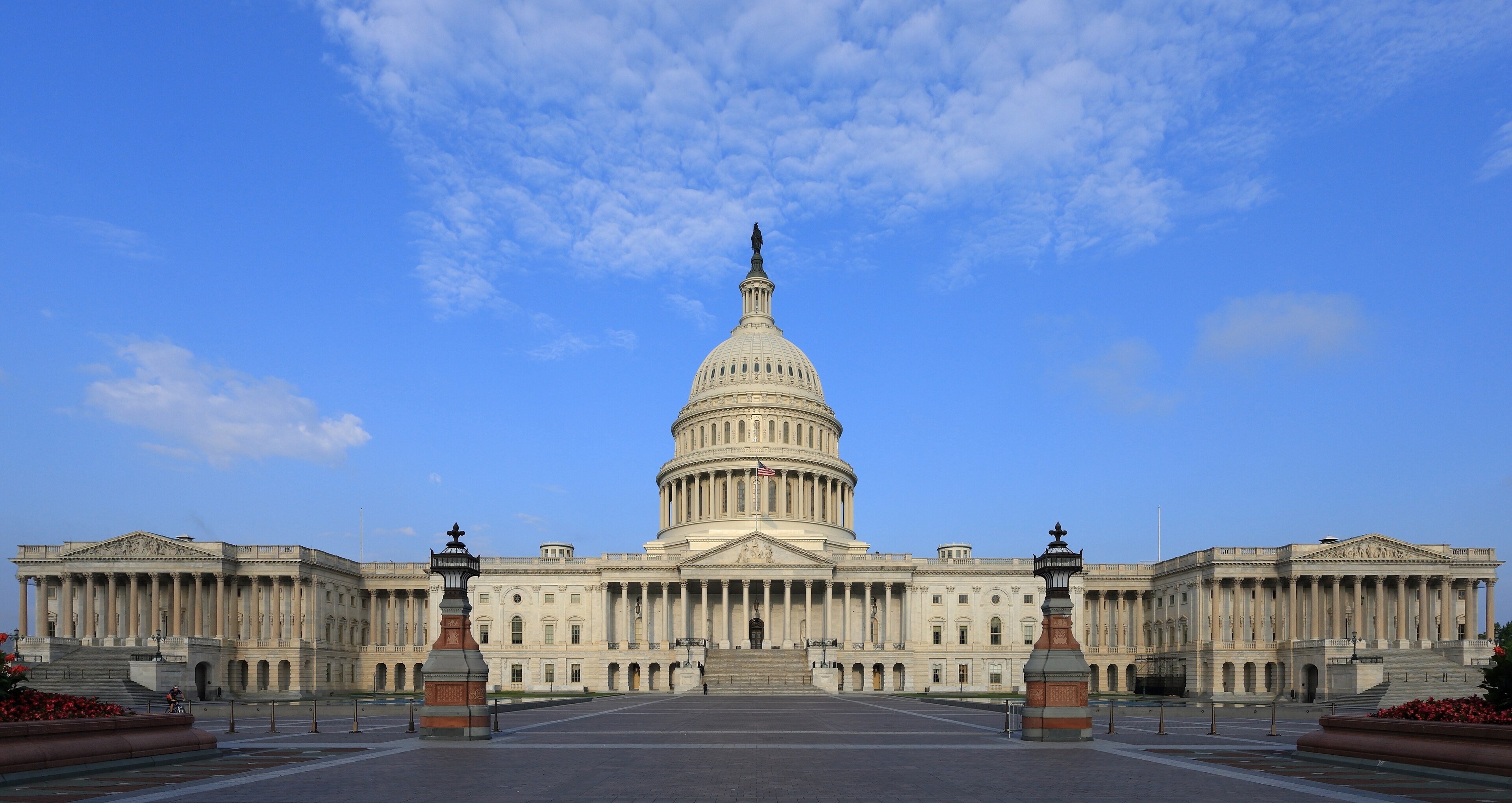 The east front of the US Capitol under clear sky, dome centered over the plaza with the Senate and House wings flanking, 2015