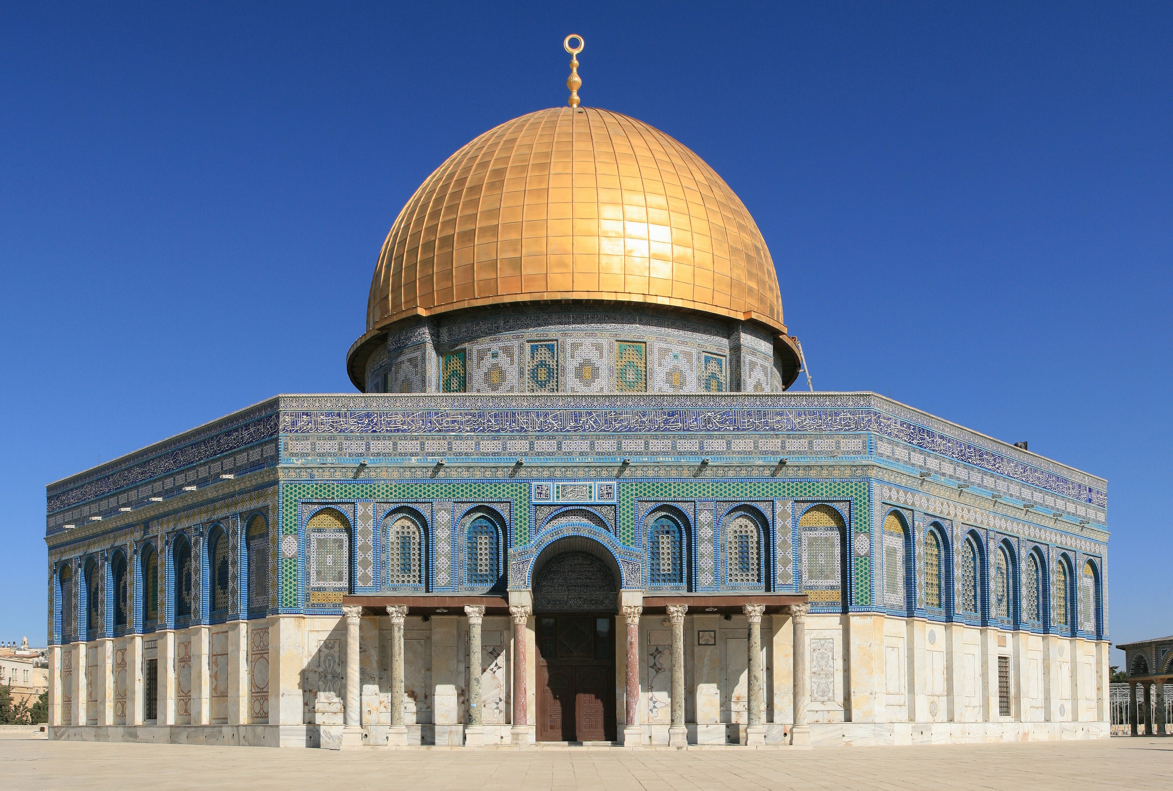 The Dome of the Rock in Jerusalem, gold dome over a tiled octagonal facade under clear sky, 2015