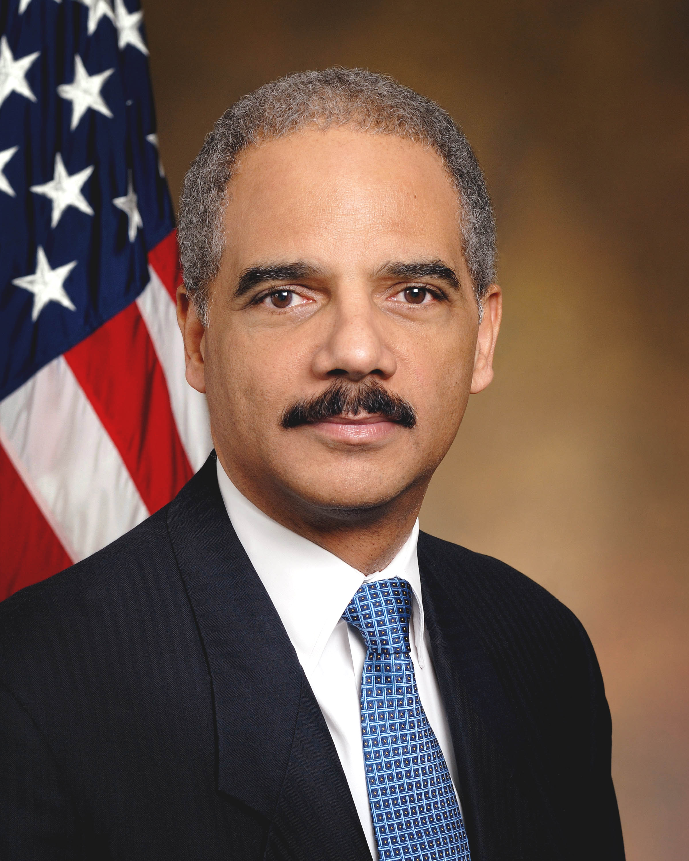 Eric Holder in his official portrait as US attorney general, the American flag behind him, 2009