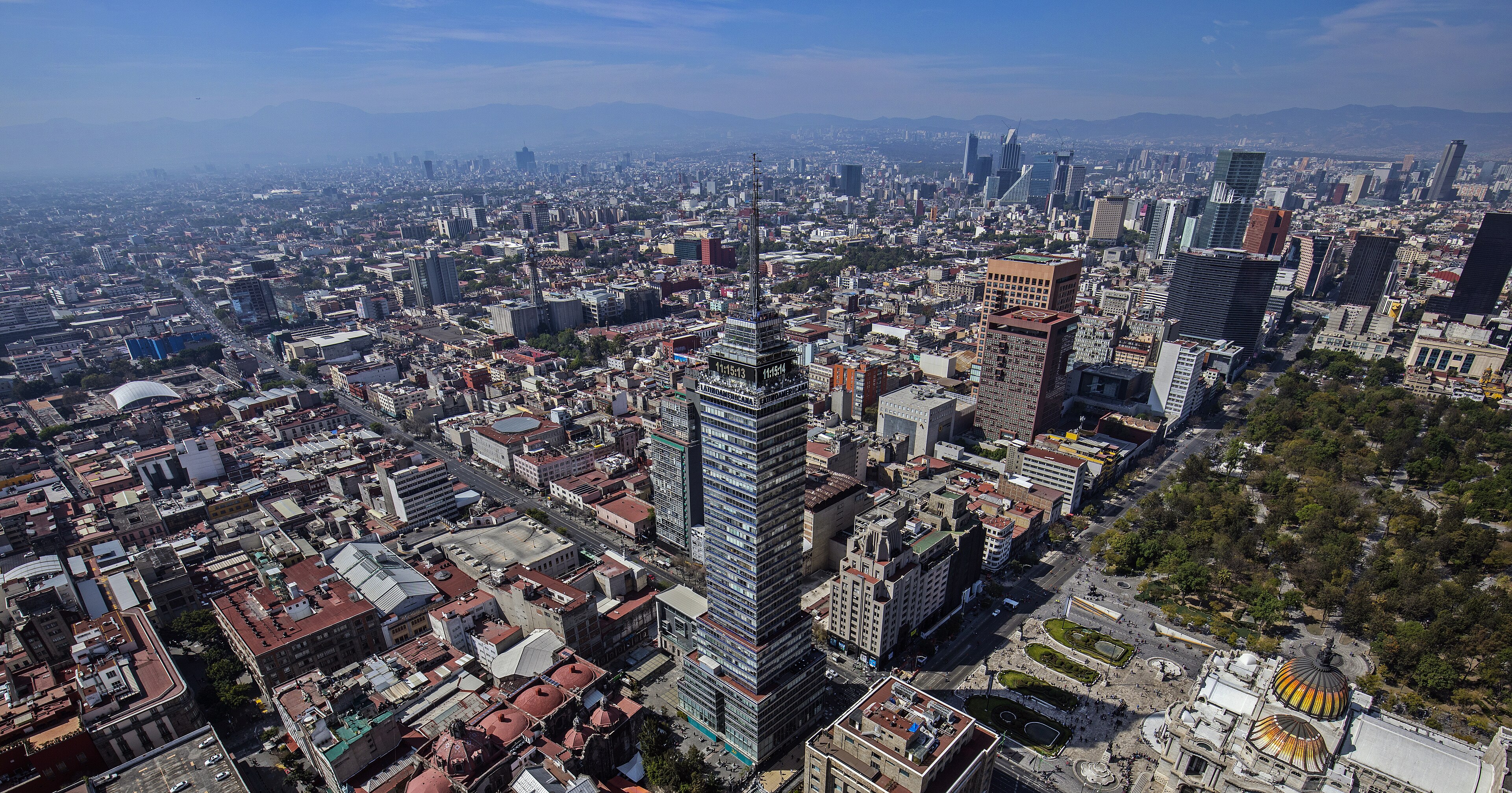 Aerial view of central Mexico City, the Torre Latinoamericana rising above red-tiled roofs with distant mountains behind, 2015
