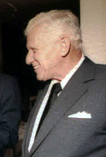 Alfred Bloomingdale in a formal portrait, dark suit with a white pocket square, 1982