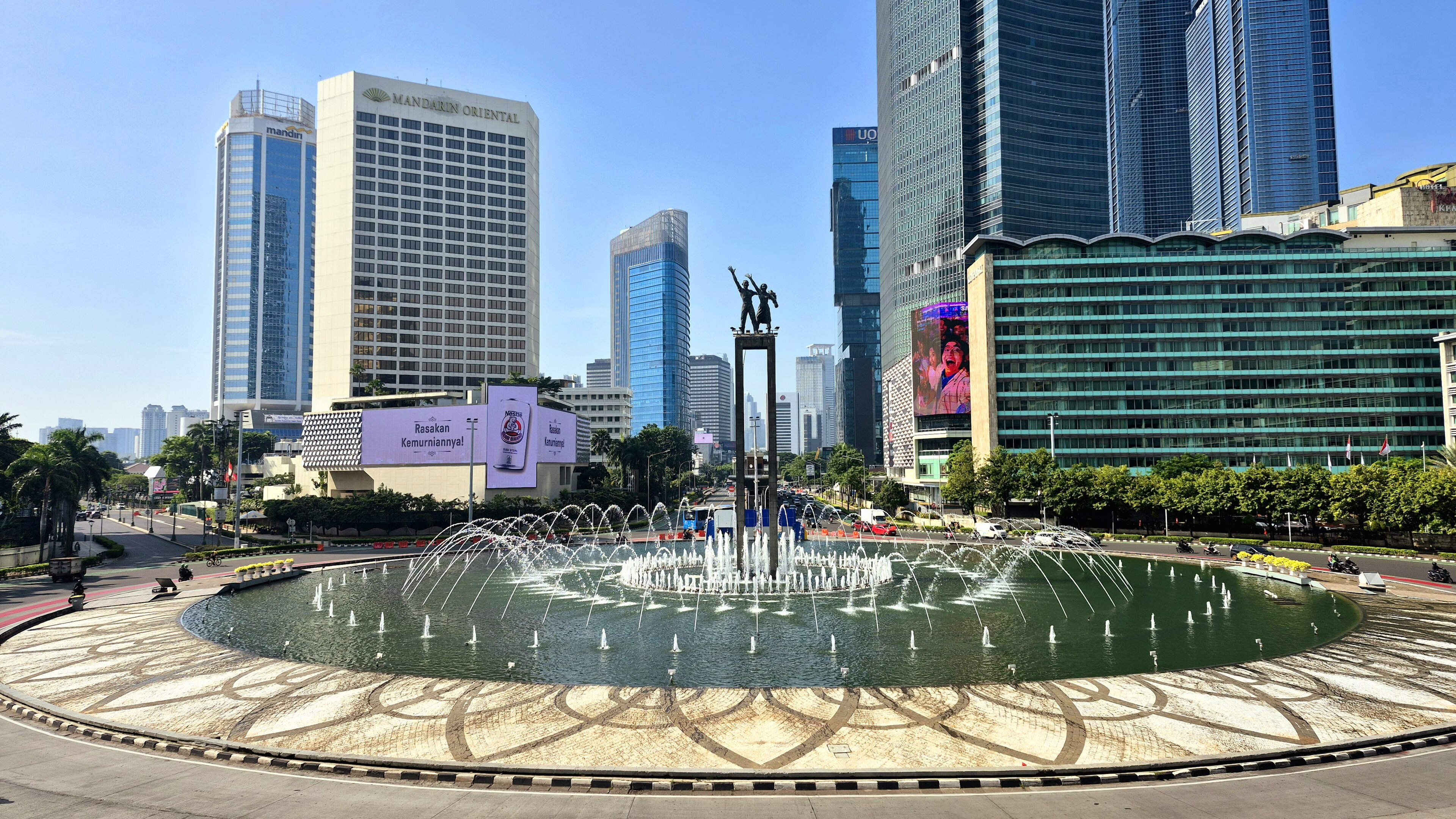The Selamat Datang monument and fountain at central Jakarta's Bundaran HI roundabout, the Mandarin Oriental and Mandiri and UOB towers ringing the plaza, 2020