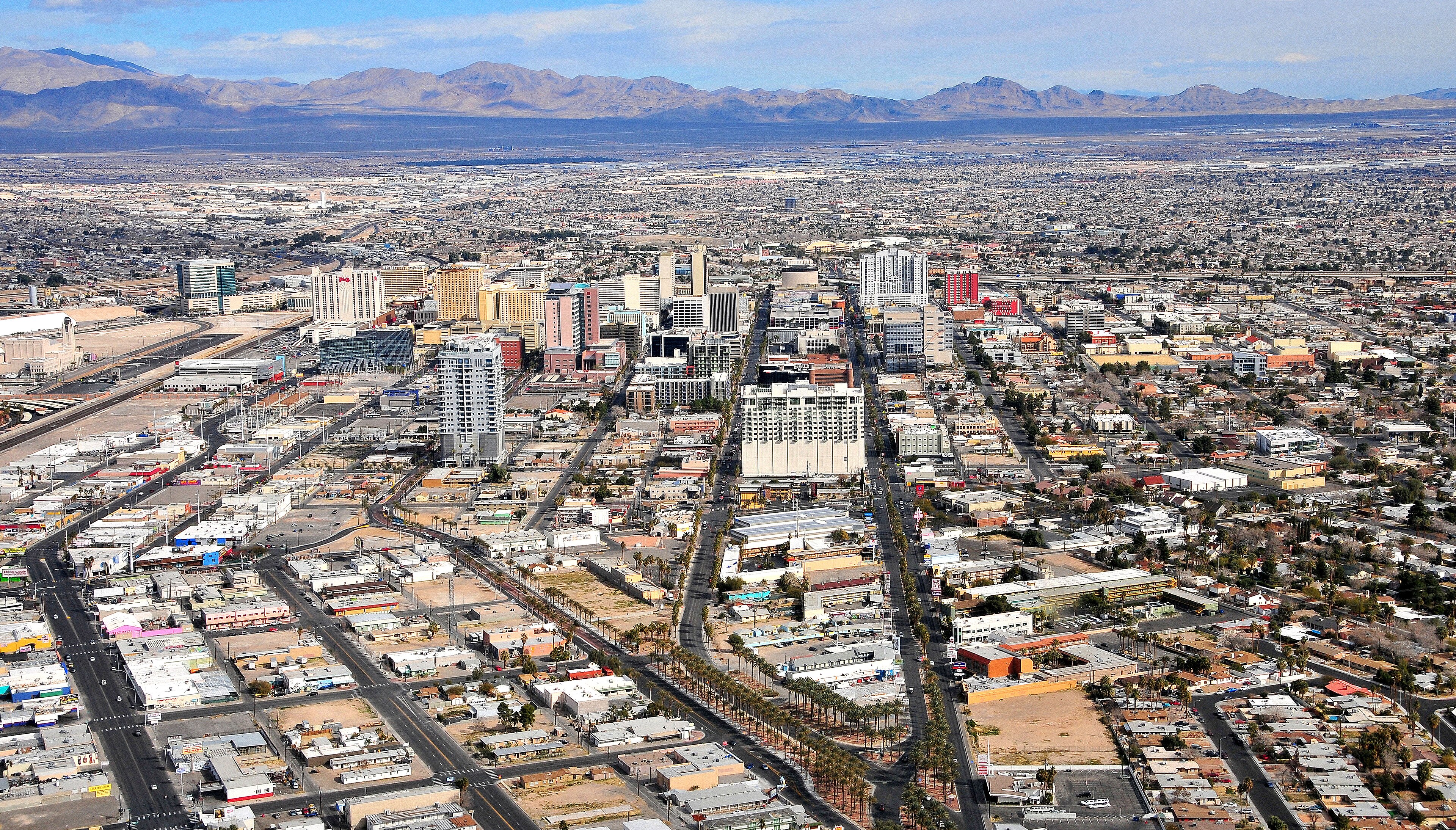 Aerial view of downtown Las Vegas casinos above the desert sprawl, mountain ridges stretching behind to the horizon, 2015