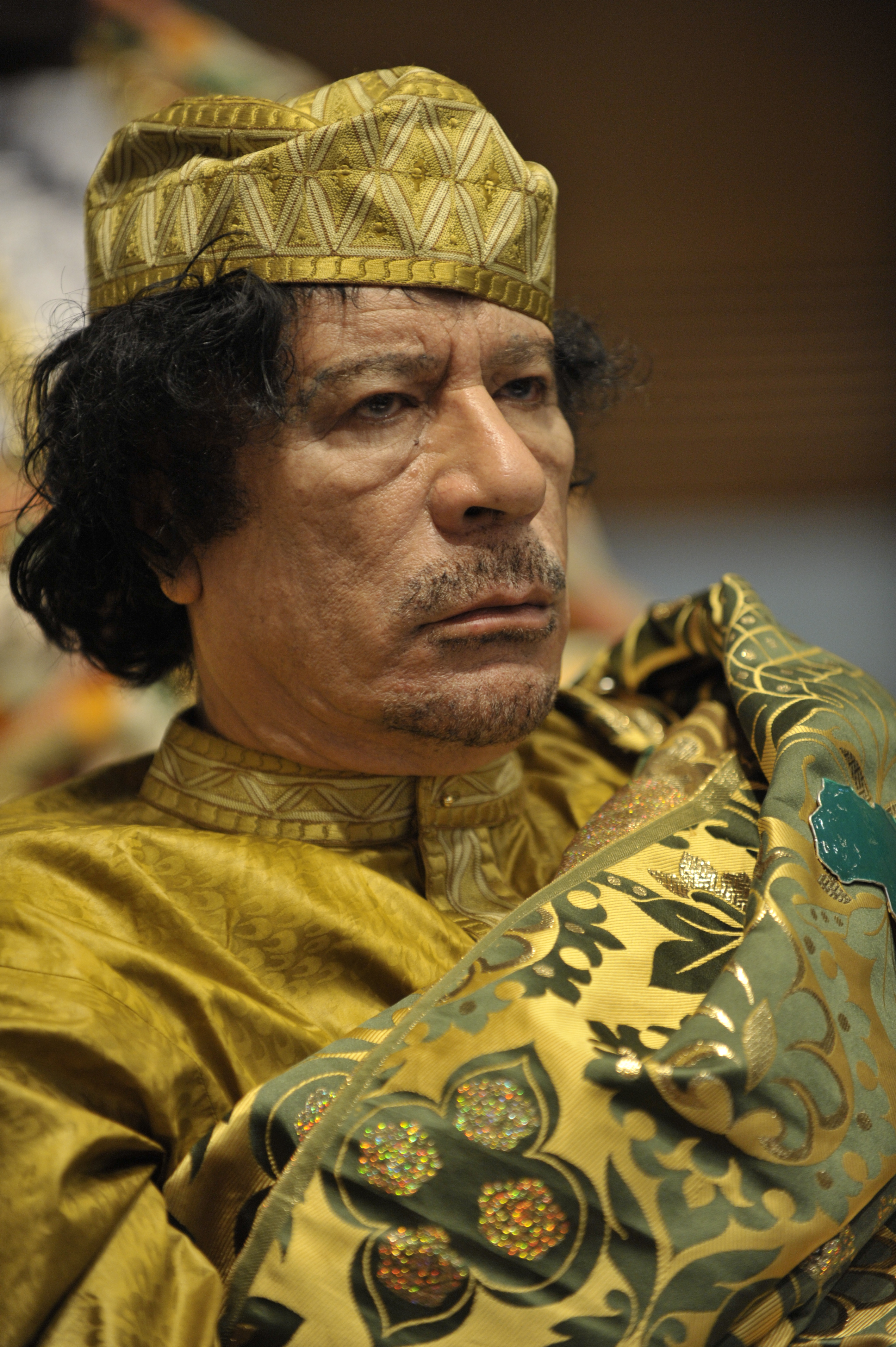 Muammar Gaddafi in embroidered gold robes and a matching kufi at an African Union summit, 2009