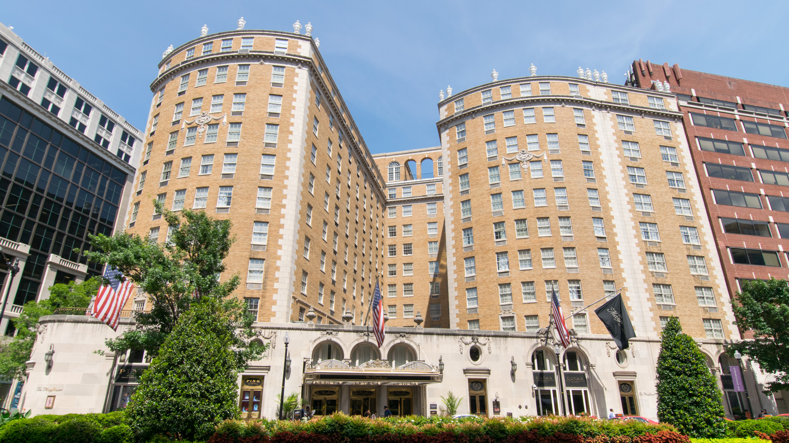 The twin rounded facades of the Mayflower Hotel on Connecticut Avenue in Washington, American flags flanking the awning, 2015