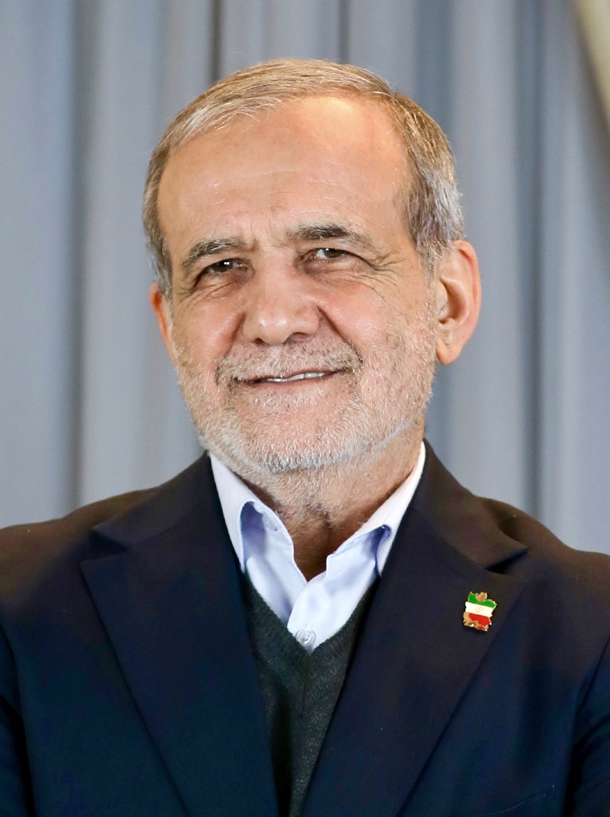 Masoud Pezeshkian smiling in a candid portrait, navy blazer over an open-collar shirt with an Iranian flag lapel pin, 2024