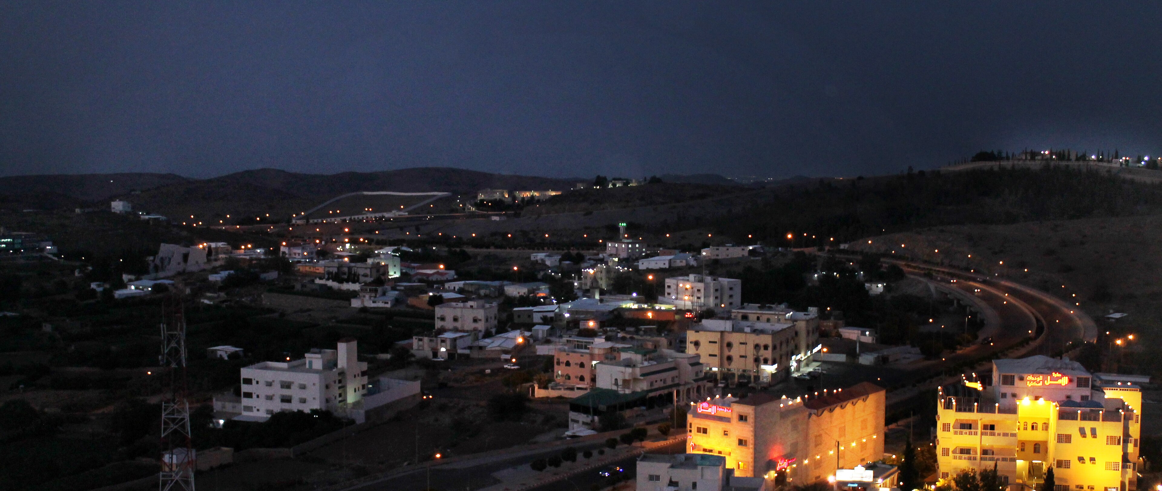 The night skyline of Taif in the Saudi highlands, lit hillside villages winding along a highway under distant hills, 2015