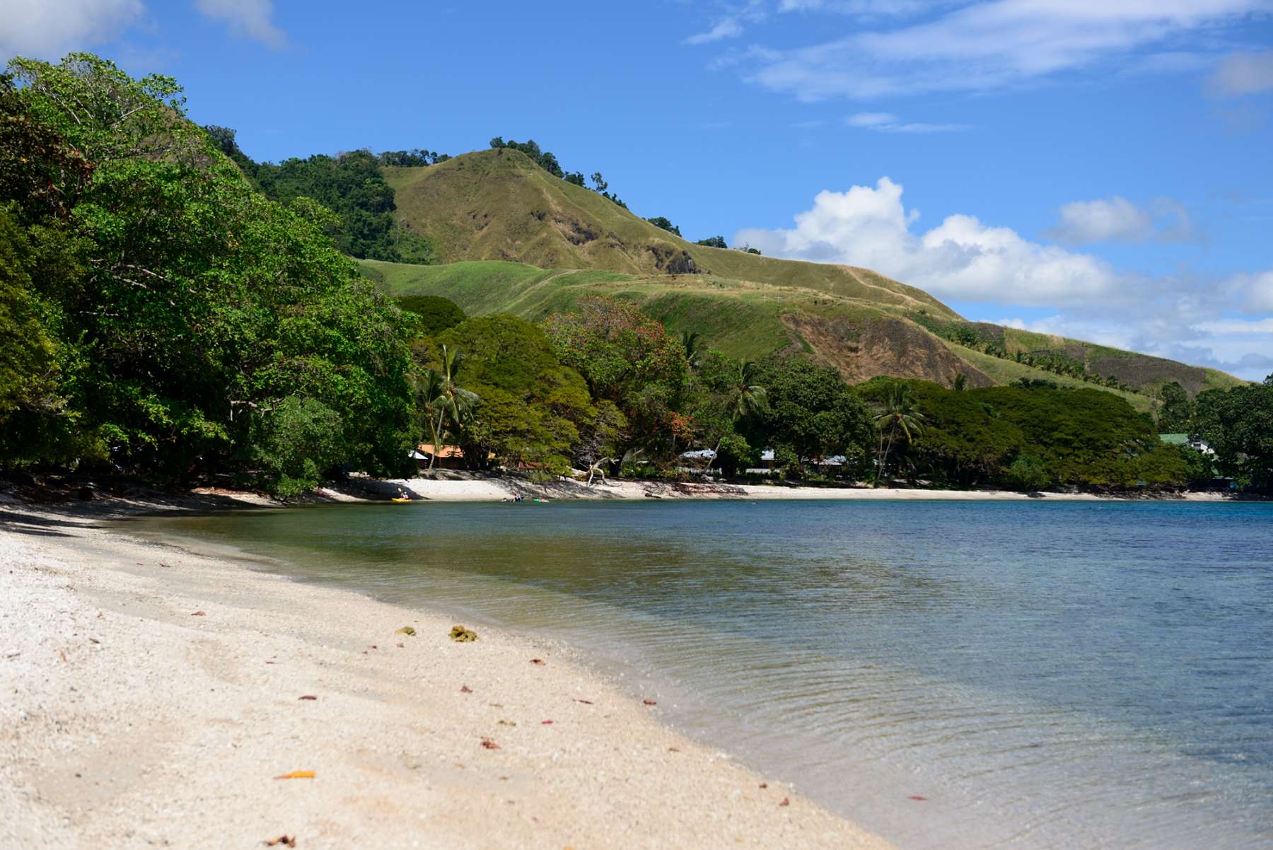 A white-sand Solomon Islands beach curving under green jungle hills above the Pacific, 2010